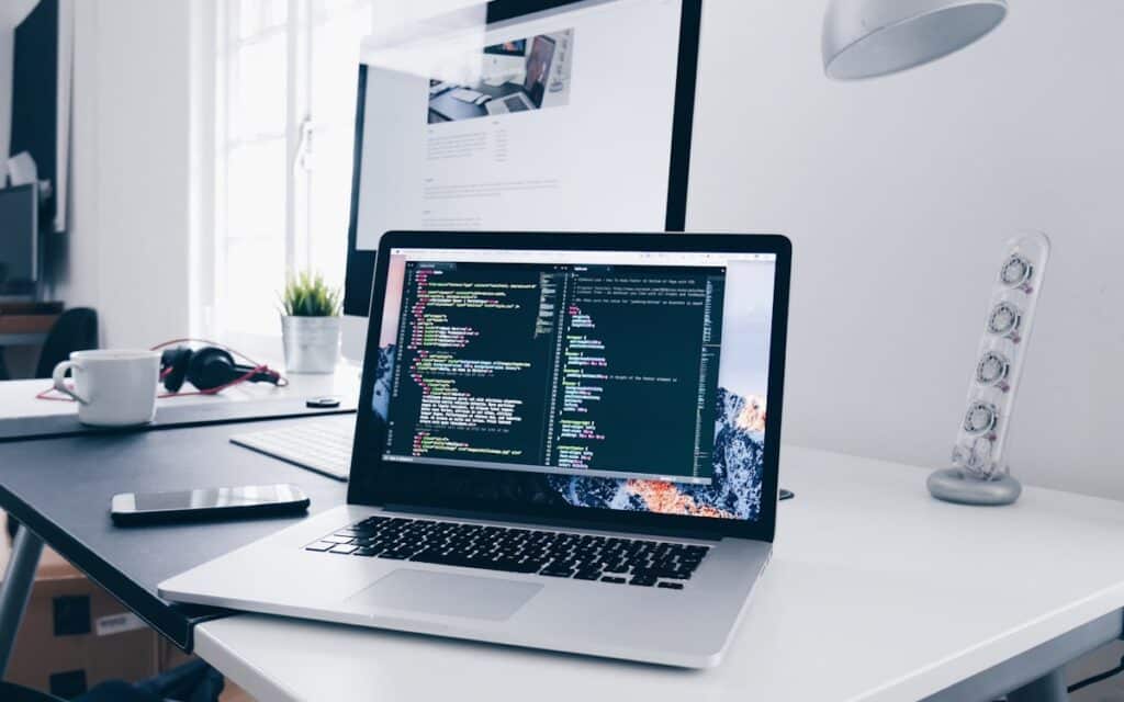 A laptop showing code on a busy desk, representing building and ranking a Melbourne tradie website